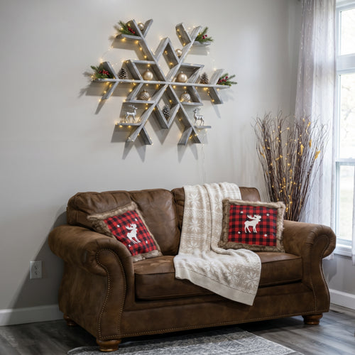 Brown leather sofa with plaid pillows and a decorative snowflake wall art in a living room.